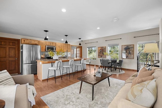 living area with recessed lighting, plenty of natural light, and light wood finished floors