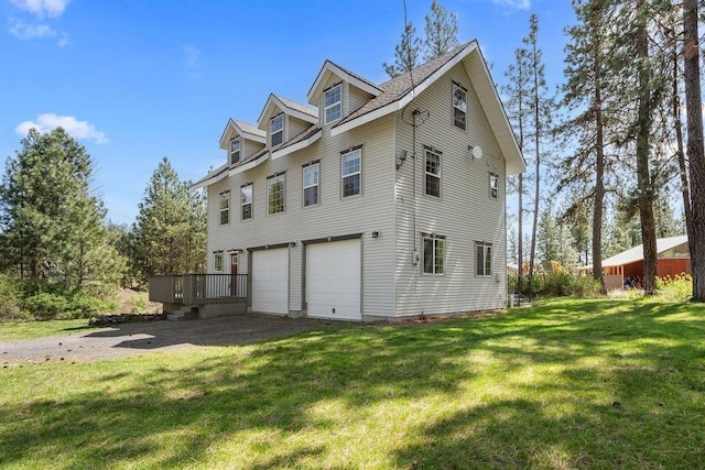view of home's exterior with a garage, a wooden deck, and a yard