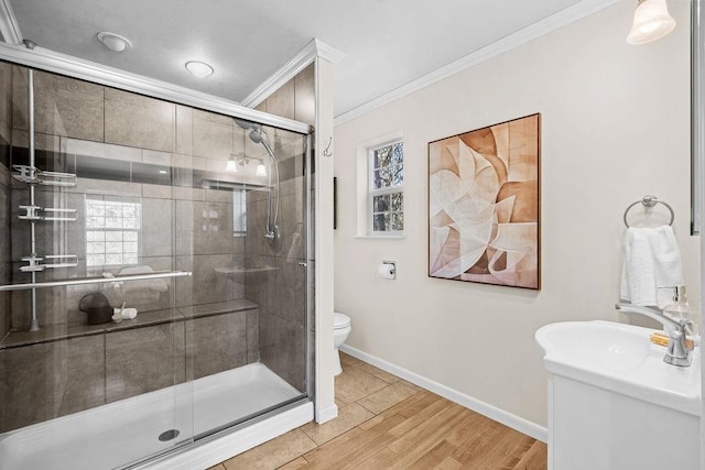 bathroom with ornamental molding, wood finished floors, toilet, baseboards, and a stall shower