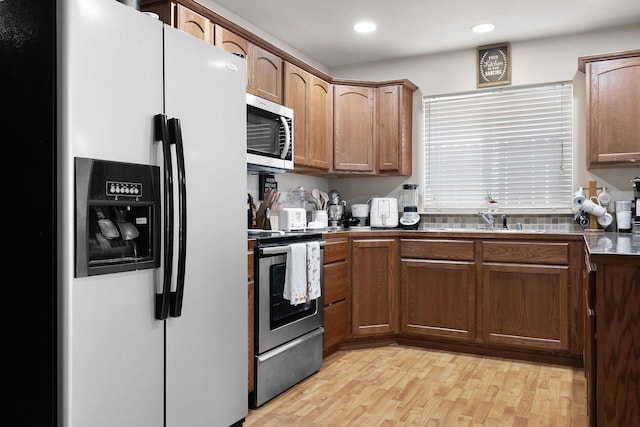 3713 S Harrison St, Spokane, WA 99224 - kitchen featuring brown cabinets, a sink, light wood-style floors, stainless steel appliances, and recessed lighting