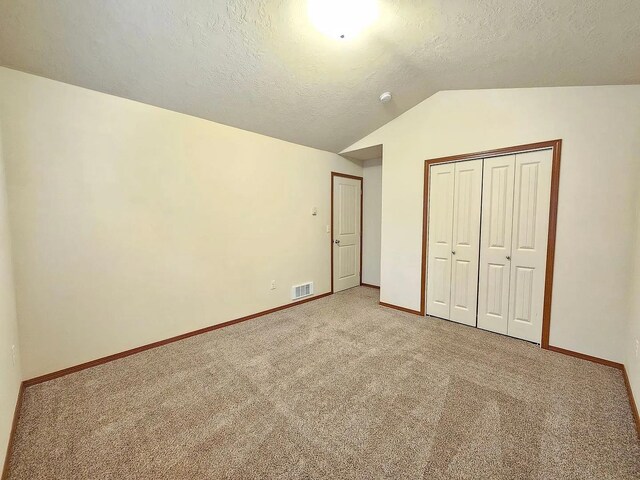 3713 S Harrison St, Spokane, WA 99224 - unfurnished bedroom with a textured ceiling, carpet, baseboards, lofted ceiling, and a closet