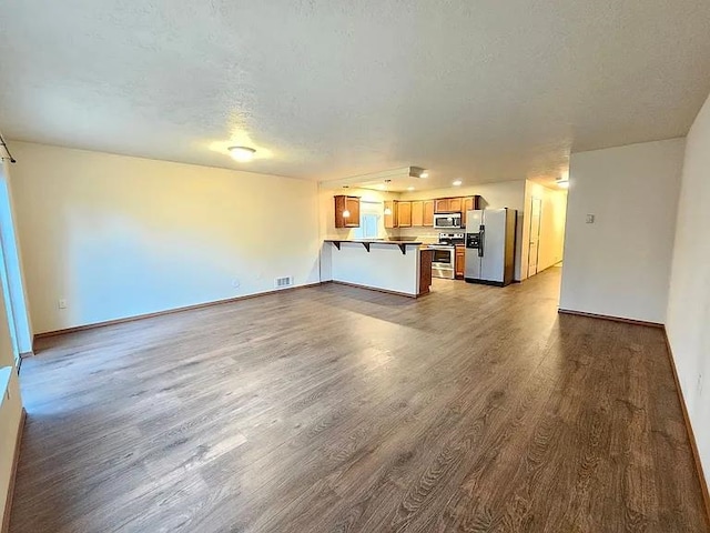 3713 S Harrison St, Spokane, WA 99224 - unfurnished living room featuring baseboards, a textured ceiling, wood finished floors, and visible vents