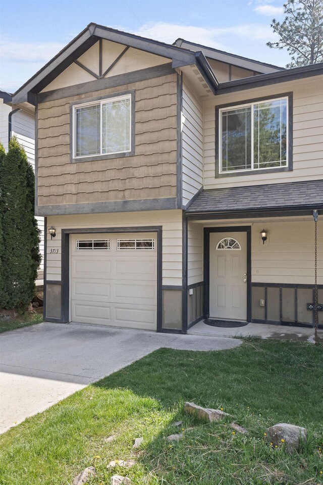 3713 S Harrison St, Spokane, WA 99224 - view of front of house featuring concrete driveway, a front lawn, and a garage