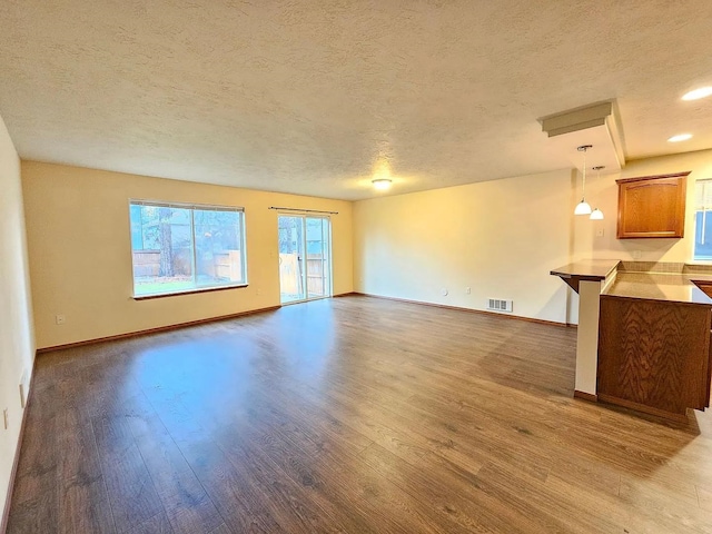 3713 S Harrison St, Spokane, WA 99224 - unfurnished living room featuring baseboards, a textured ceiling, visible vents, and wood finished floors