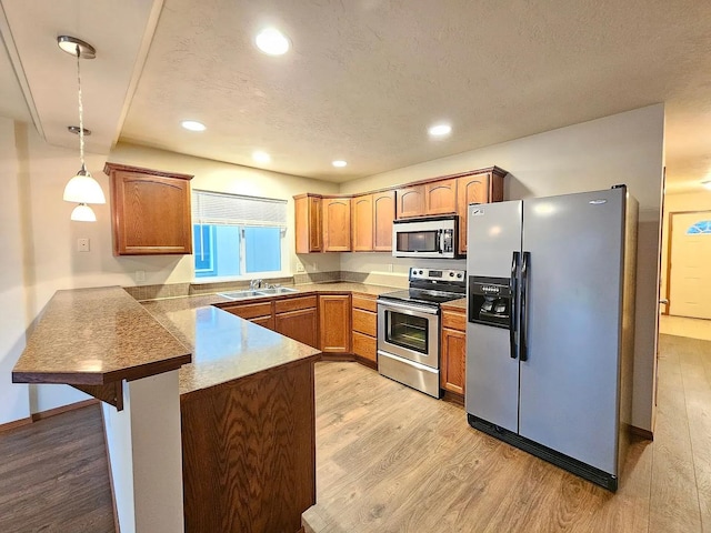 3713 S Harrison St, Spokane, WA 99224 - kitchen with a kitchen breakfast bar, appliances with stainless steel finishes, a sink, a peninsula, and light wood-style flooring