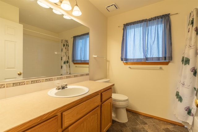 bathroom with visible vents, vanity, curtained shower, toilet, and baseboards