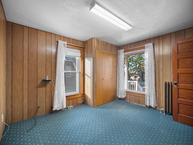218 S Broadway St, Tekoa, WA 99033 - unfurnished bedroom featuring carpet, radiator heating unit, and wooden walls