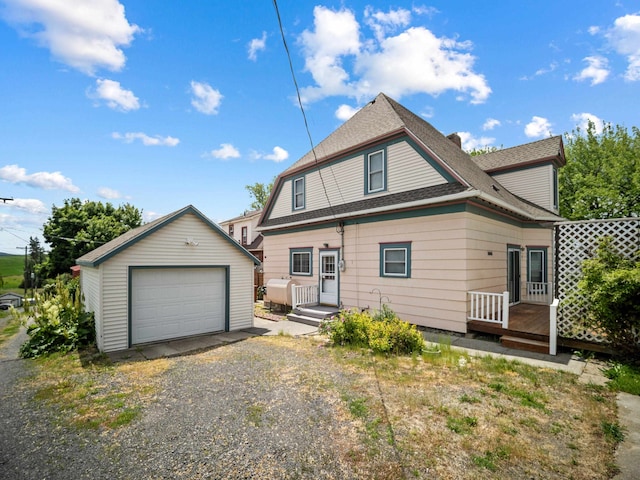 218 S Broadway St, Tekoa, WA 99033 - view of front of home featuring an outbuilding, a garage, driveway, roof with shingles, and a wooden deck