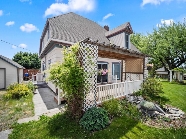218 S Broadway St, Tekoa, WA 99033 - view of property exterior featuring a pergola, a shingled roof, a chimney, and covered porch