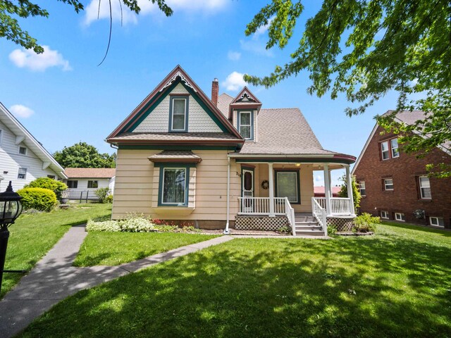 218 S Broadway St, Tekoa, WA 99033 - victorian house featuring a porch, a front lawn, and a chimney