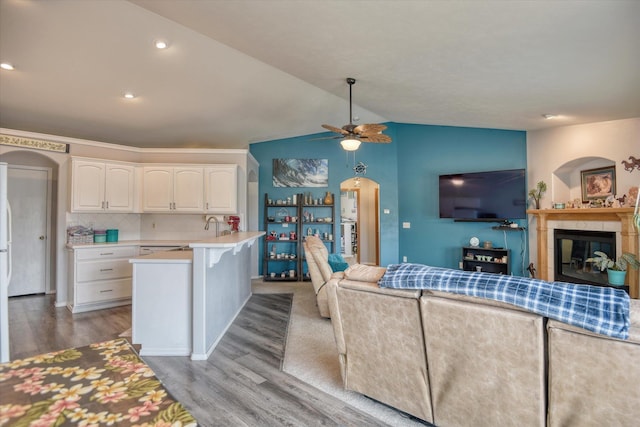 6805 Royal Ln, Spokane, WA 99208 - kitchen with open floor plan, wood finished floors, arched walkways, lofted ceiling, and white cabinets