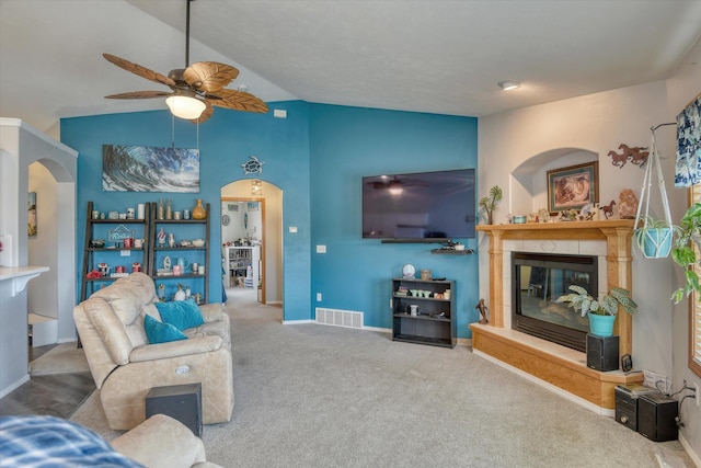 6805 Royal Ln, Spokane, WA 99208 - living room with arched walkways, lofted ceiling, a ceiling fan, a tile fireplace, and carpet floors