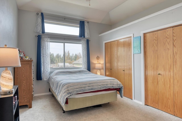 6805 Royal Ln, Spokane, WA 99208 - bedroom with light carpet, two closets, baseboards, and vaulted ceiling