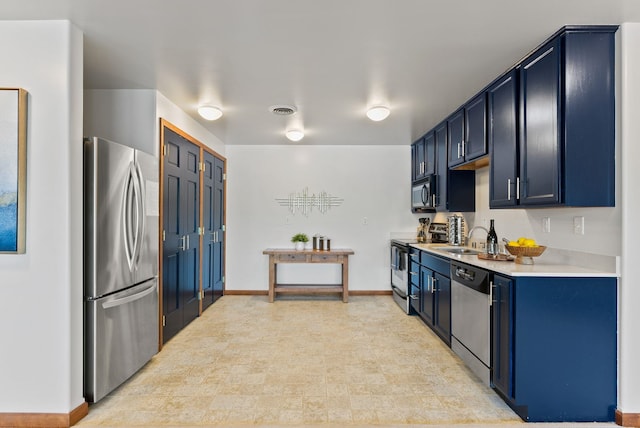 kitchen featuring blue cabinets, visible vents, a sink, light countertops, and stainless steel appliances