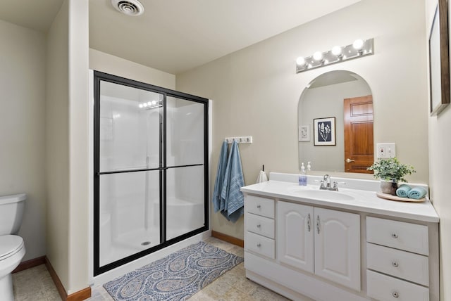 bathroom featuring visible vents, a shower stall, vanity, baseboards, and toilet