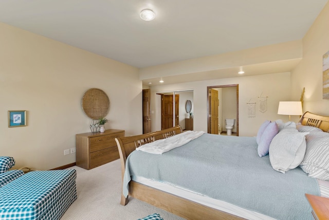 bedroom featuring connected bathroom and carpet
