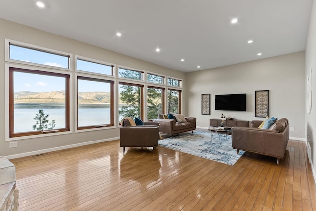 living room with recessed lighting, baseboards, visible vents, and light wood finished floors
