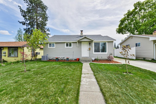 view of front of home with central AC unit, a front lawn, fence, and a chimney