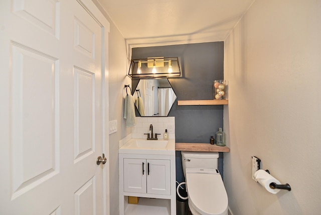 bathroom featuring backsplash, toilet, and vanity