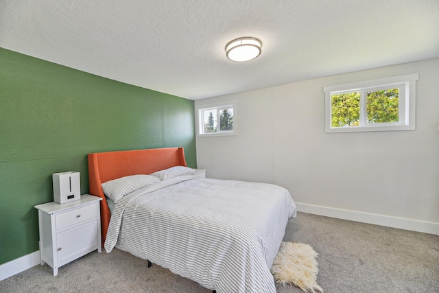 bedroom with a textured ceiling, baseboards, and light colored carpet
