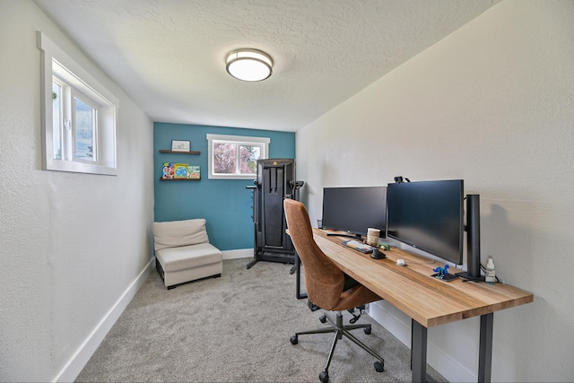 carpeted home office with baseboards and a textured ceiling