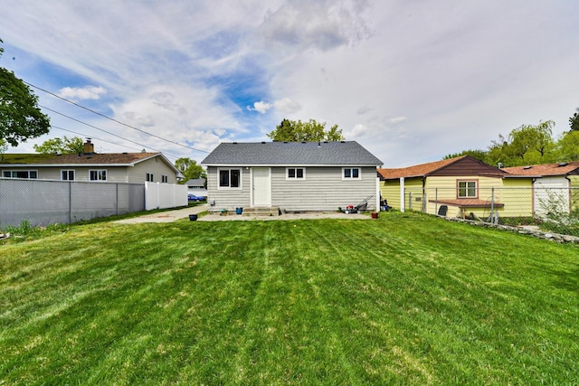 back of property featuring entry steps, a lawn, and a fenced backyard