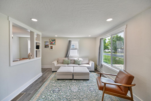living room with baseboards, a textured ceiling, recessed lighting, and wood finished floors