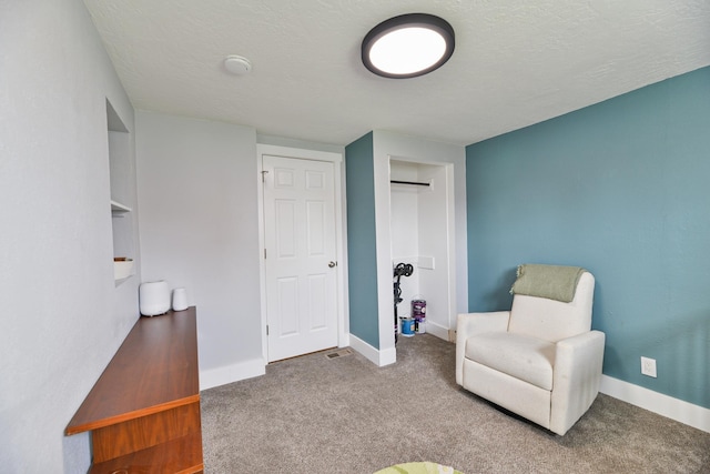 sitting room featuring baseboards and carpet flooring