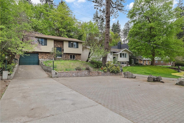 split foyer home with a garage, a front lawn, stone siding, and concrete driveway
