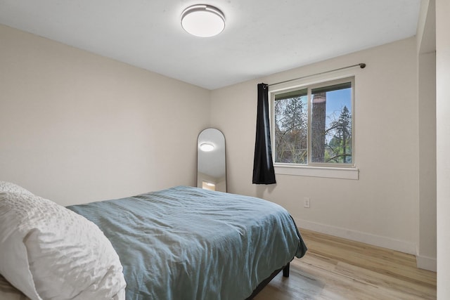 bedroom with baseboards and wood finished floors