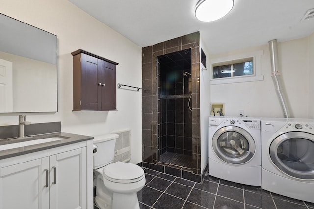 full bath with a shower stall, washing machine and dryer, vanity, tile patterned floors, and toilet