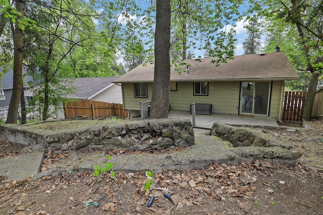 back of house featuring a patio area, fence, and roof with shingles