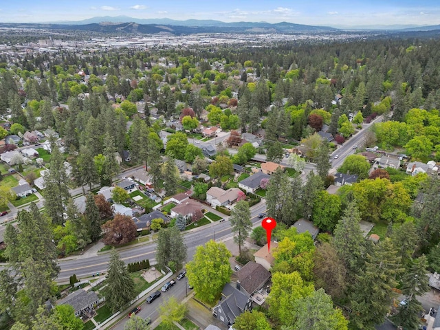 birds eye view of property featuring a wooded view, a residential view, and a mountain view