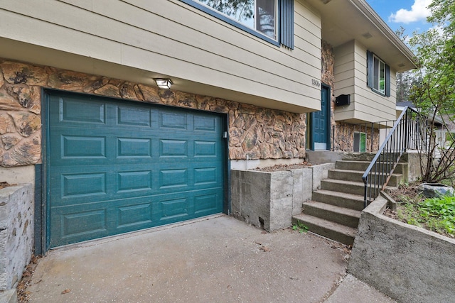 exterior space featuring a garage, driveway, and stone siding