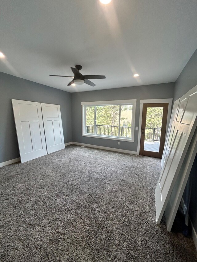 unfurnished bedroom with baseboards, access to outside, and multiple windows