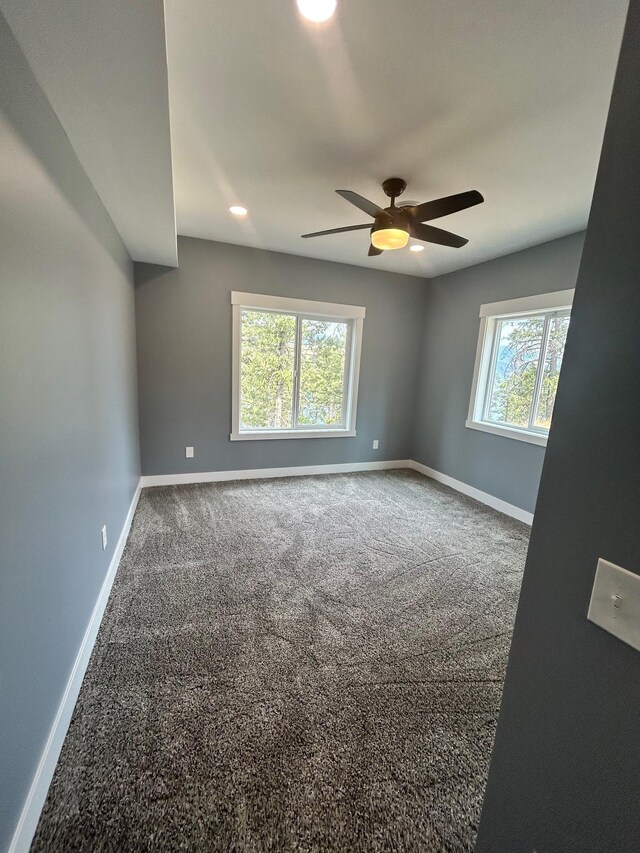 unfurnished room featuring carpet flooring, a ceiling fan, and baseboards
