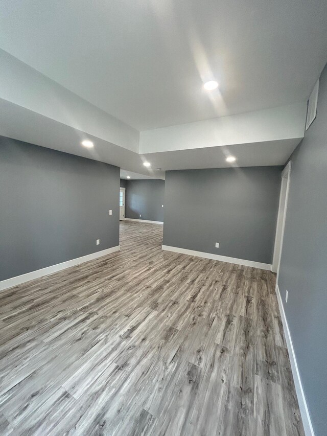 finished below grade area with baseboards, recessed lighting, and wood finished floors