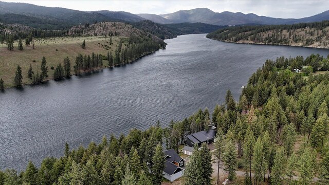 aerial view with a water and mountain view and a forest view