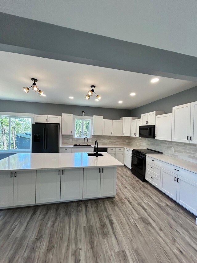 kitchen featuring a sink, white cabinetry, black appliances, and tasteful backsplash