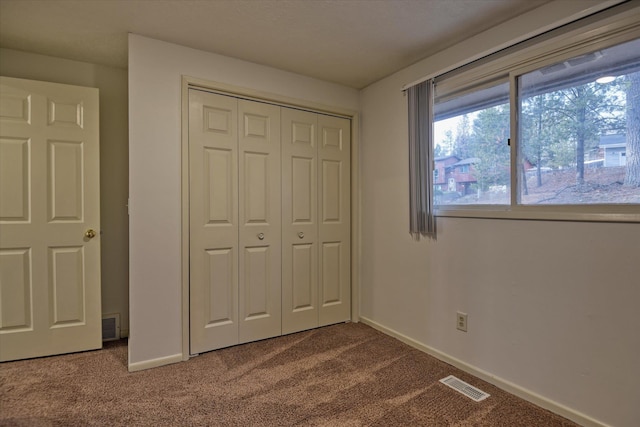 2514 E Casper Dr, Spokane, WA 99223 - unfurnished bedroom with baseboards, a closet, dark colored carpet, and visible vents