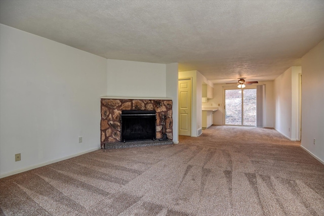 2514 E Casper Dr, Spokane, WA 99223 - unfurnished living room with a ceiling fan, baseboards, a stone fireplace, and carpet