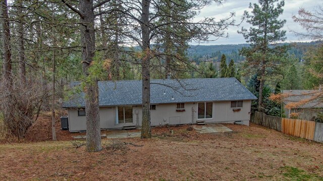 2514 E Casper Dr, Spokane, WA 99223 - back of house with fence, a view of trees, central air condition unit, and a shingled roof