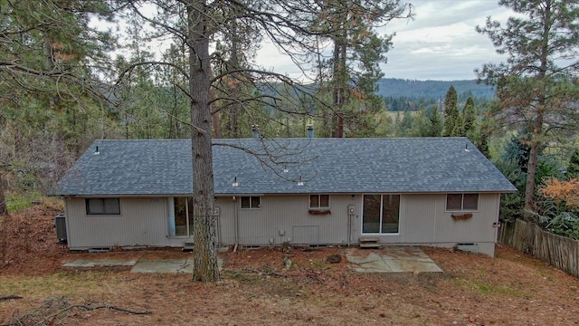 2514 E Casper Dr, Spokane, WA 99223 - rear view of house featuring a wooded view, fence, a shingled roof, and a patio