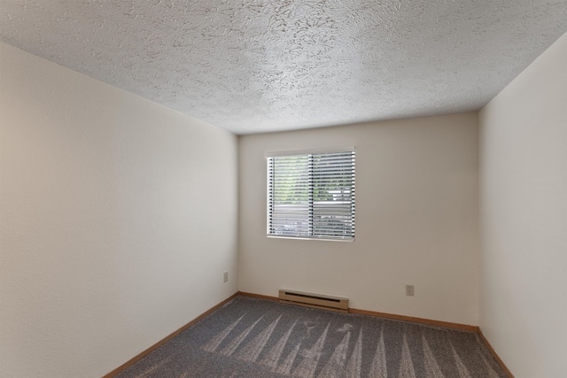 empty room featuring a textured ceiling, a baseboard heating unit, baseboards, and dark colored carpet