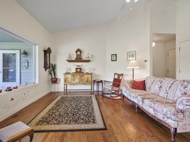 living room with baseboards, ceiling fan, and wood finished floors