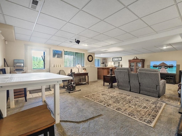 carpeted living room featuring visible vents and a paneled ceiling