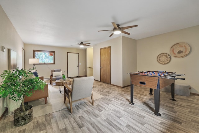 game room with light wood-style floors, baseboards, and ceiling fan