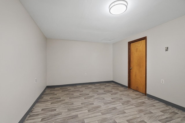 empty room featuring baseboards and light wood finished floors