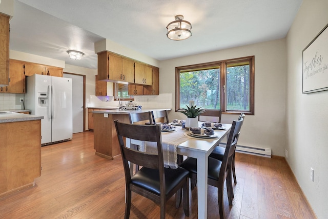 dining room featuring a baseboard heating unit and light wood-type flooring