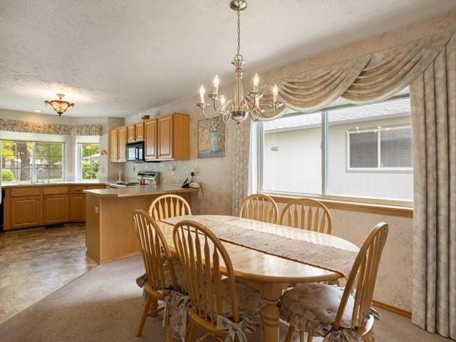 8409 N Pine Meadows Ln, Nine Mile Falls, WA 99026 - dining area featuring light carpet, a textured ceiling, and a chandelier